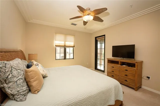 a bedroom with a bed and a flat tv screen on dresser