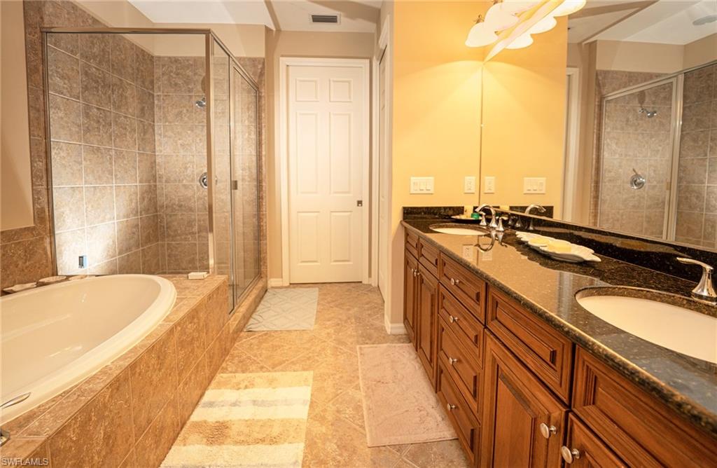 9054 Capistrano Street North, Unit 4002 Naples, FL 34113 - Photo 12 of 26 a spacious bathroom with a tub sink and mirror