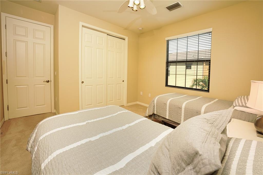 9054 Capistrano Street North, Unit 4002 Naples, FL 34113 - Photo 17 of 26 a bedroom with two beds and painted walls