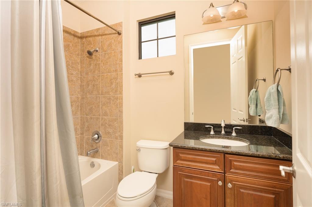 9054 Capistrano Street North, Unit 4002 Naples, FL 34113 - Photo 18 of 26 a bathroom with a granite countertop sink toilet and shower