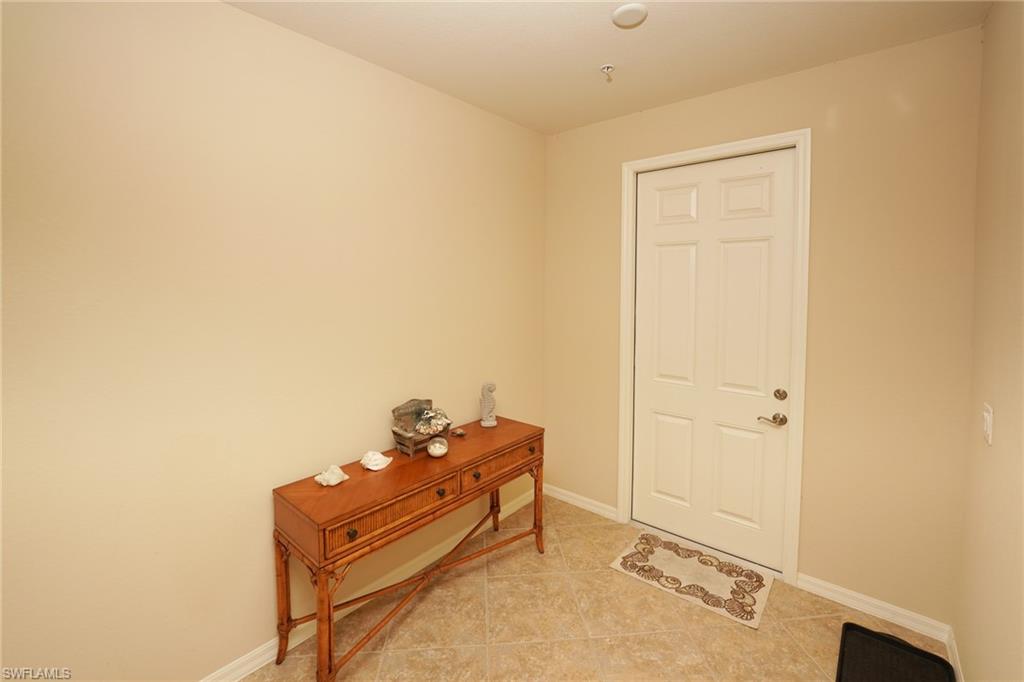 9054 Capistrano Street North, Unit 4002 Naples, FL 34113 - Photo 21 of 26 a room with a bed and a mirror