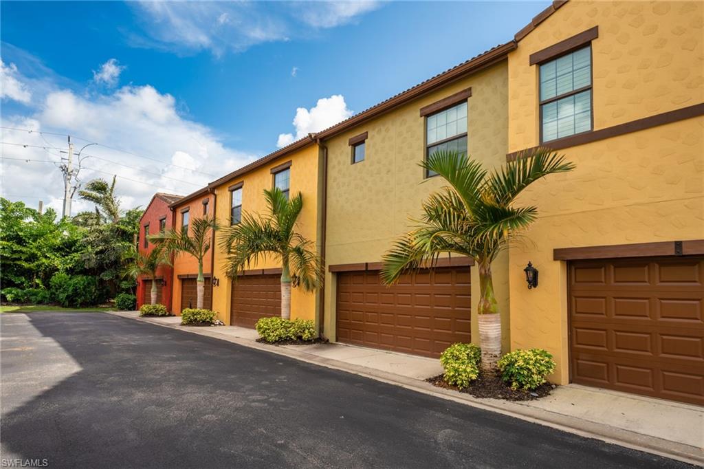 9054 Capistrano Street North, Unit 4002 Naples, FL 34113 - Photo 24 of 26 a front view of a house with a yard and garage