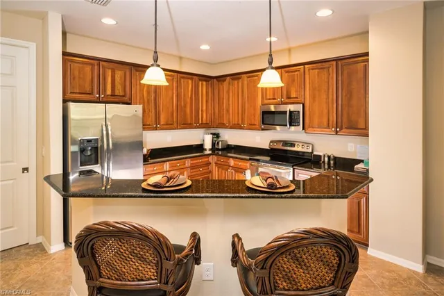 a kitchen with kitchen island a stove a sink and a refrigerator with wooden floor