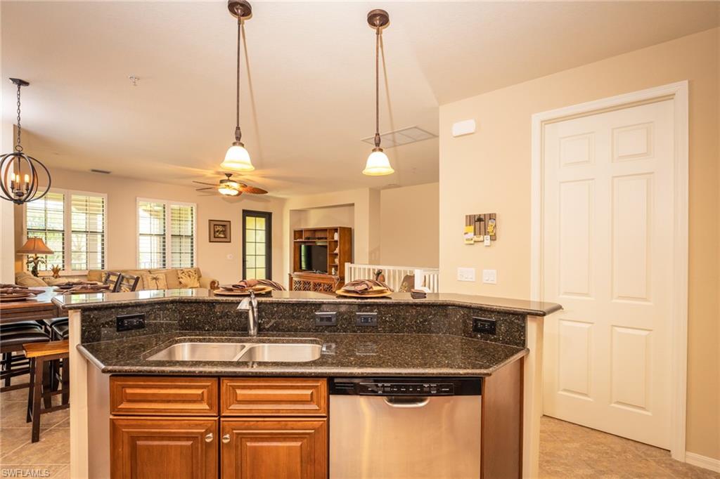 9054 Capistrano Street North, Unit 4002 Naples, FL 34113 - Photo 26 of 26 a kitchen with stainless steel appliances granite countertop a sink a counter space and a chandelier