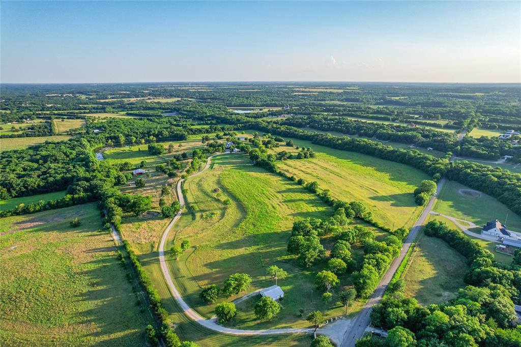 1922 A Bethel-Cannon Road Whitewright, TX 75491 - Photo 1 of 40 Expansive rural landscape featuring a winding gravel road and abundant green fields