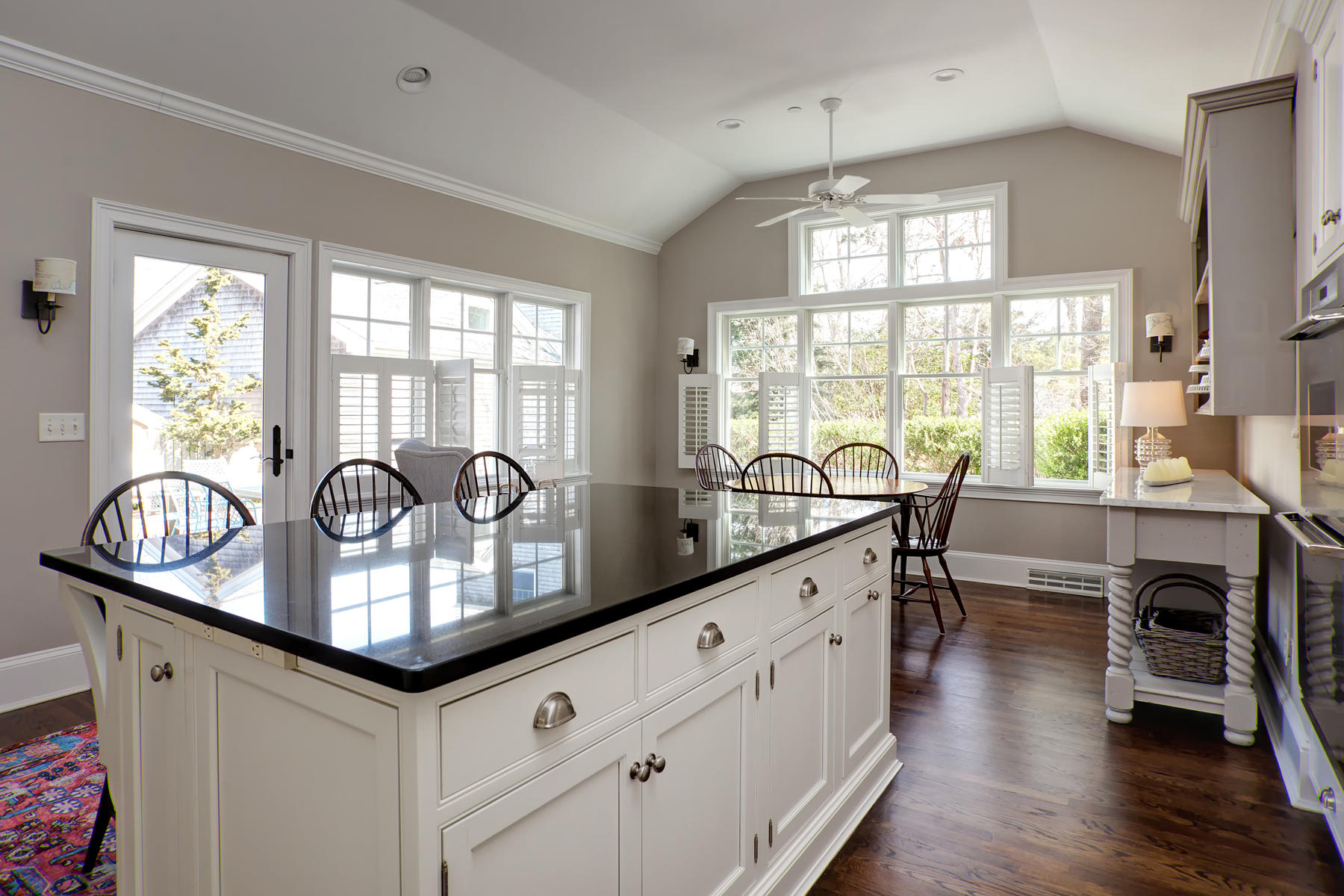199 East Bay Road, Unit 12 Osterville, MA 02655 - Photo 15 of 40 a kitchen with granite countertop cabinets a dining table and chairs with wooden floors