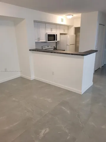 a view of a kitchen with stainless steel appliances cabinets