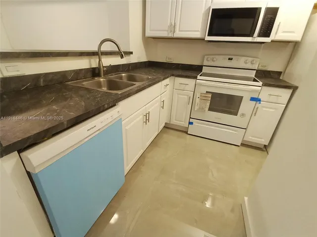 a kitchen with a sink and a stove top oven