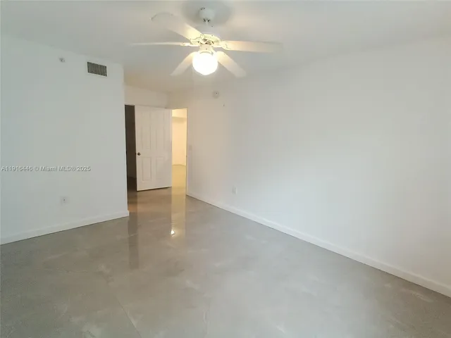 an empty room with a ceiling fan and a window