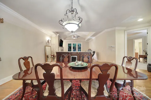 a living room with furniture a dining table and a chandelier