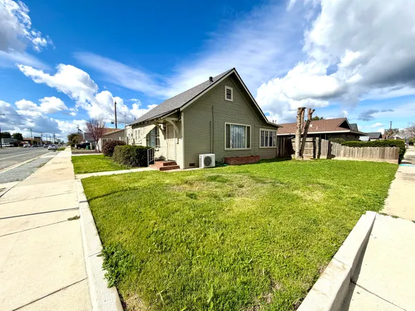 a view of a house with a big yard and potted plants