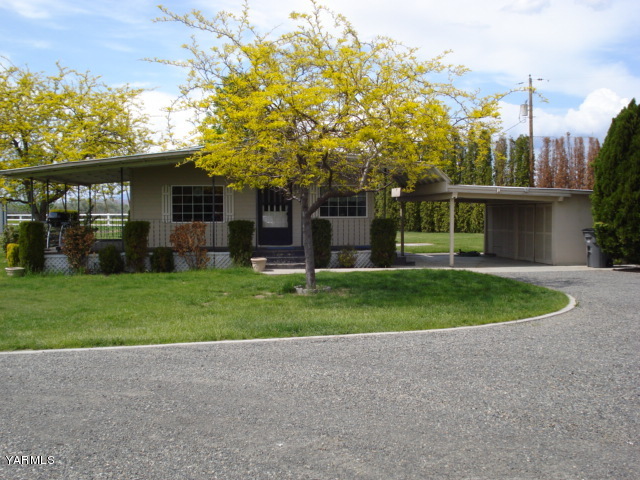 a front view of a house with a yard and trees
