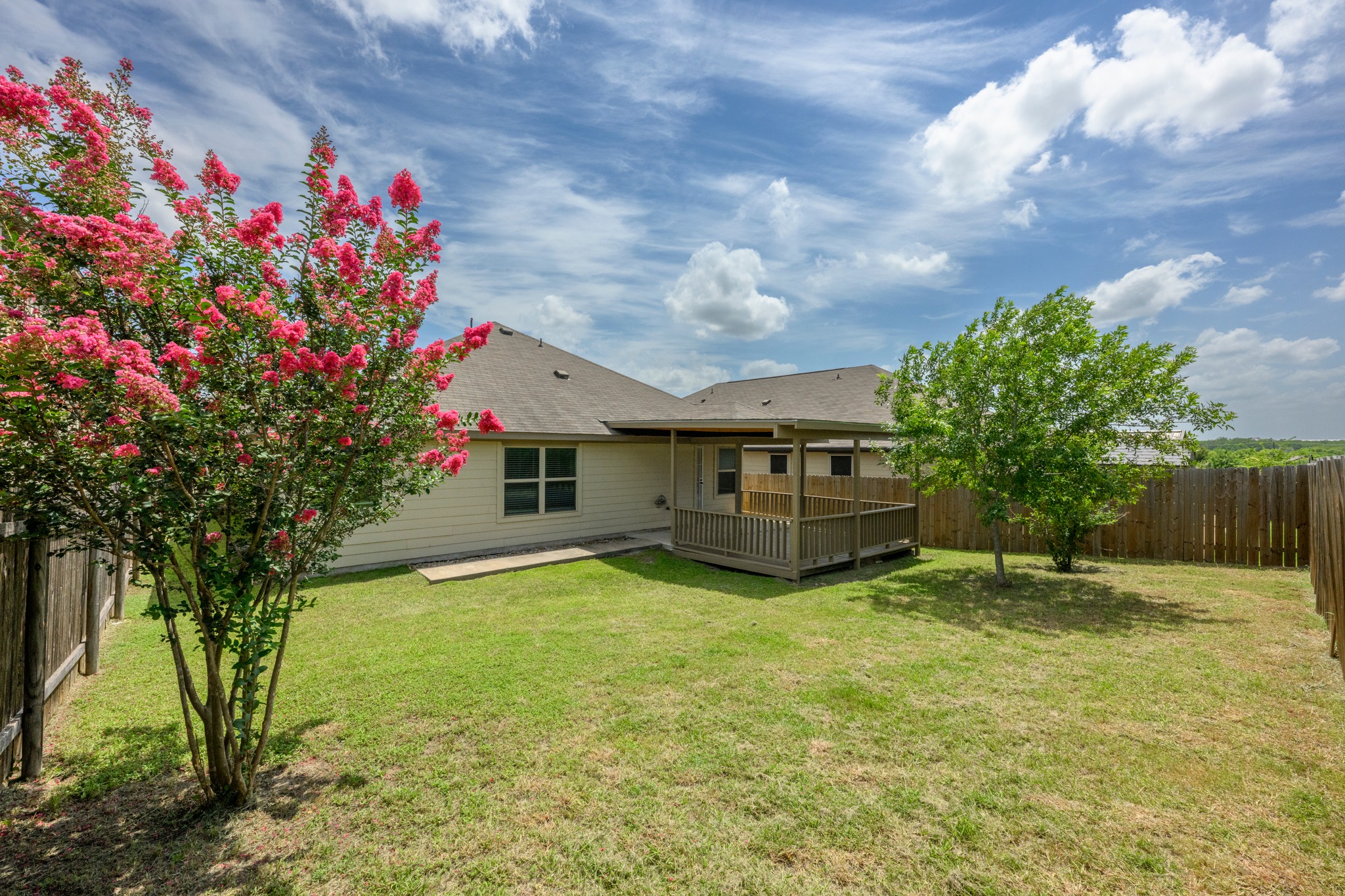 278 Noddy Road Buda, TX 78610 - Photo 16 of 17 A private backyard featuring lush green grass and a charming covered patio for outdoor enjoyment.