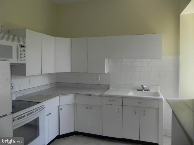 1705 South Road Baltimore, MD 21209 - Photo 6 of 29 a kitchen with white cabinets sink and dishwasher