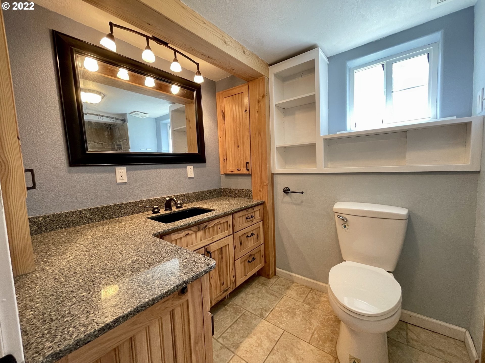 2275 Oak Street North Bend, OR 97459 - Photo 23 of 30 a bathroom with a granite countertop toilet sink and mirror