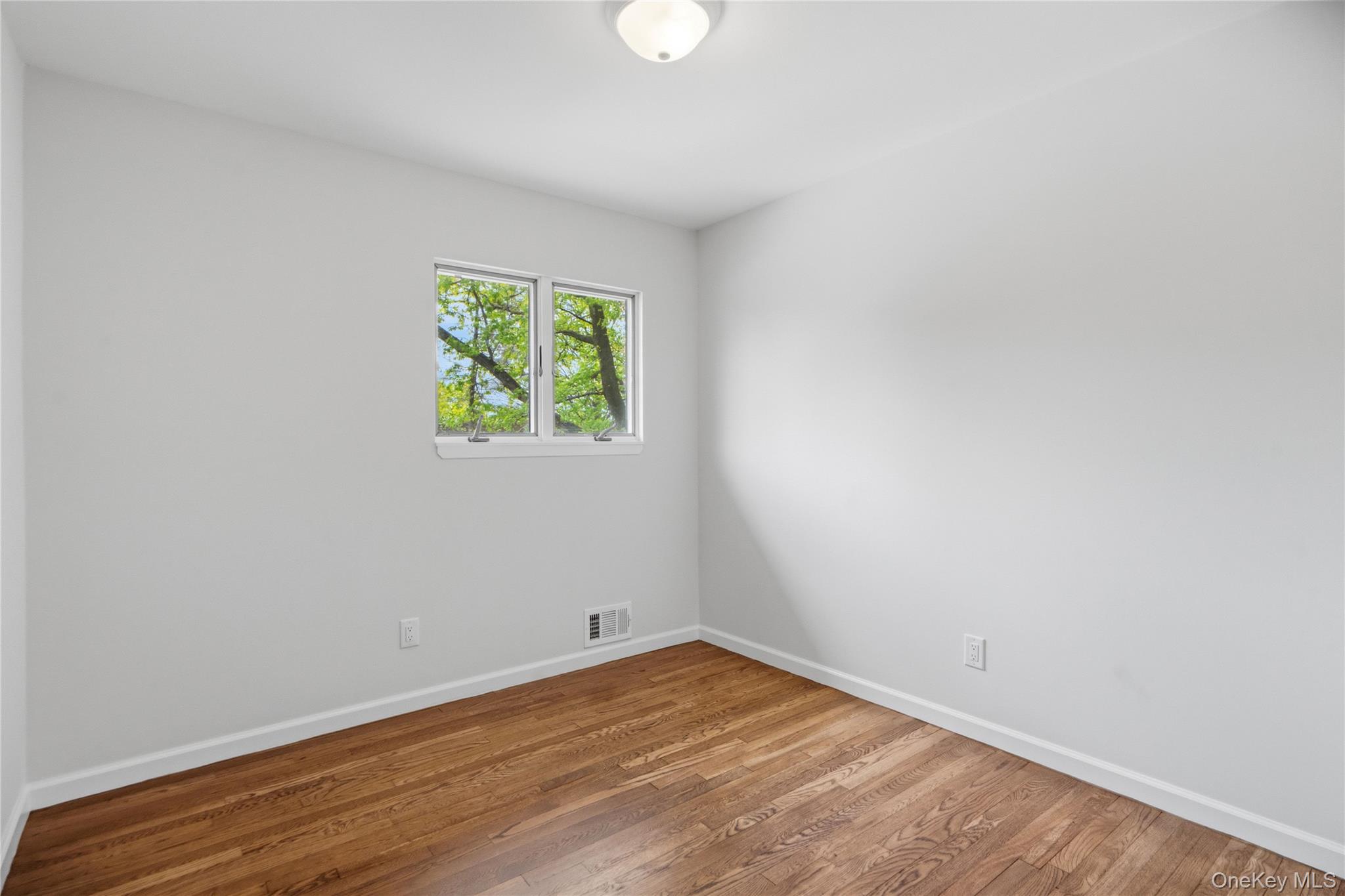 183 North Marginal Road Jericho, NY 11753 - Photo 20 of 28 Third Bedroom with Bright interior with hardwood flooring, white baseboards, and a flush-mount ceiling light fixture