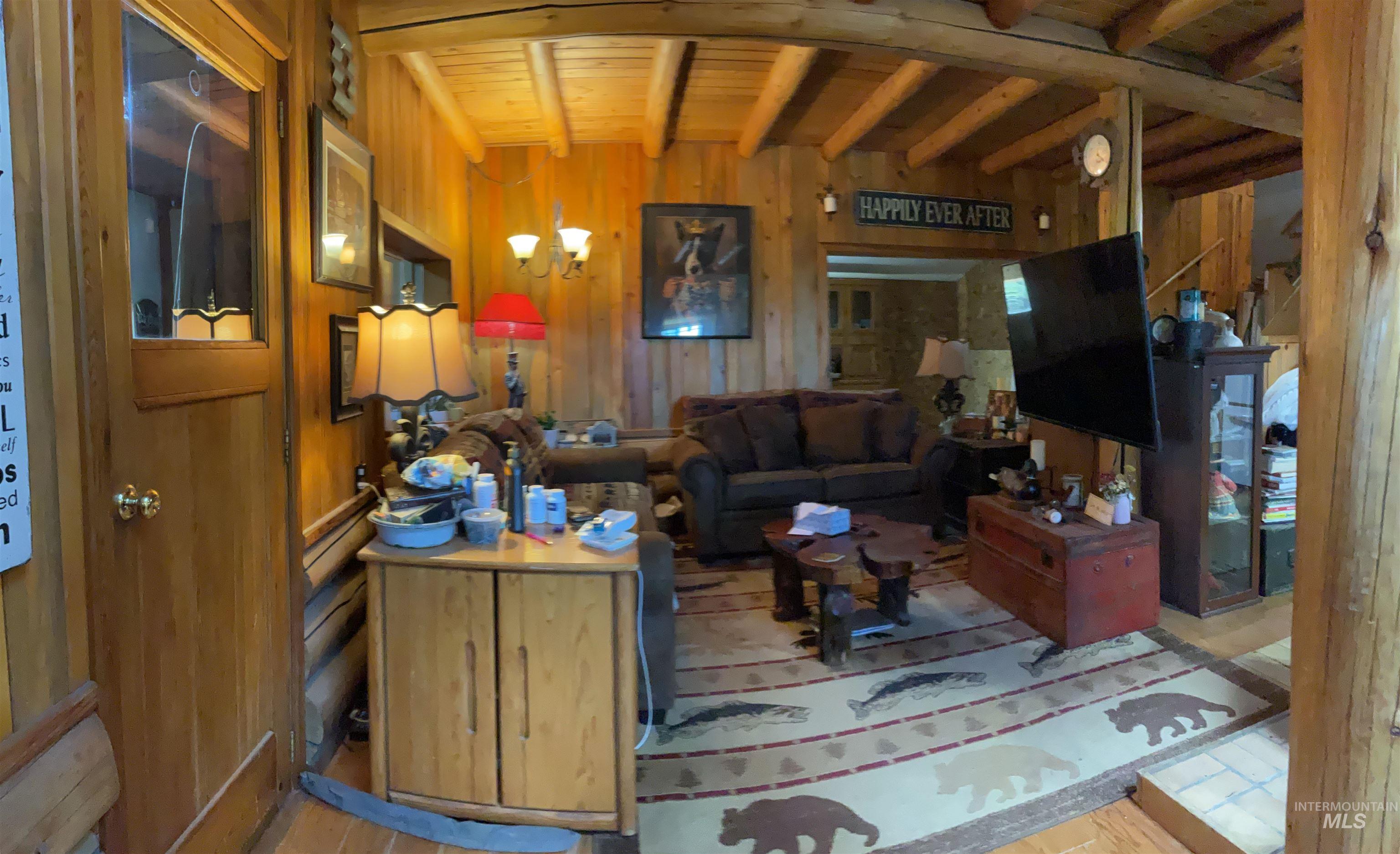 176 West Buffalo Gulch Road Elk City, ID 83525 - Photo 18 of 38 Wood-paneled living space featuring exposed log beams and wood-finish flooring