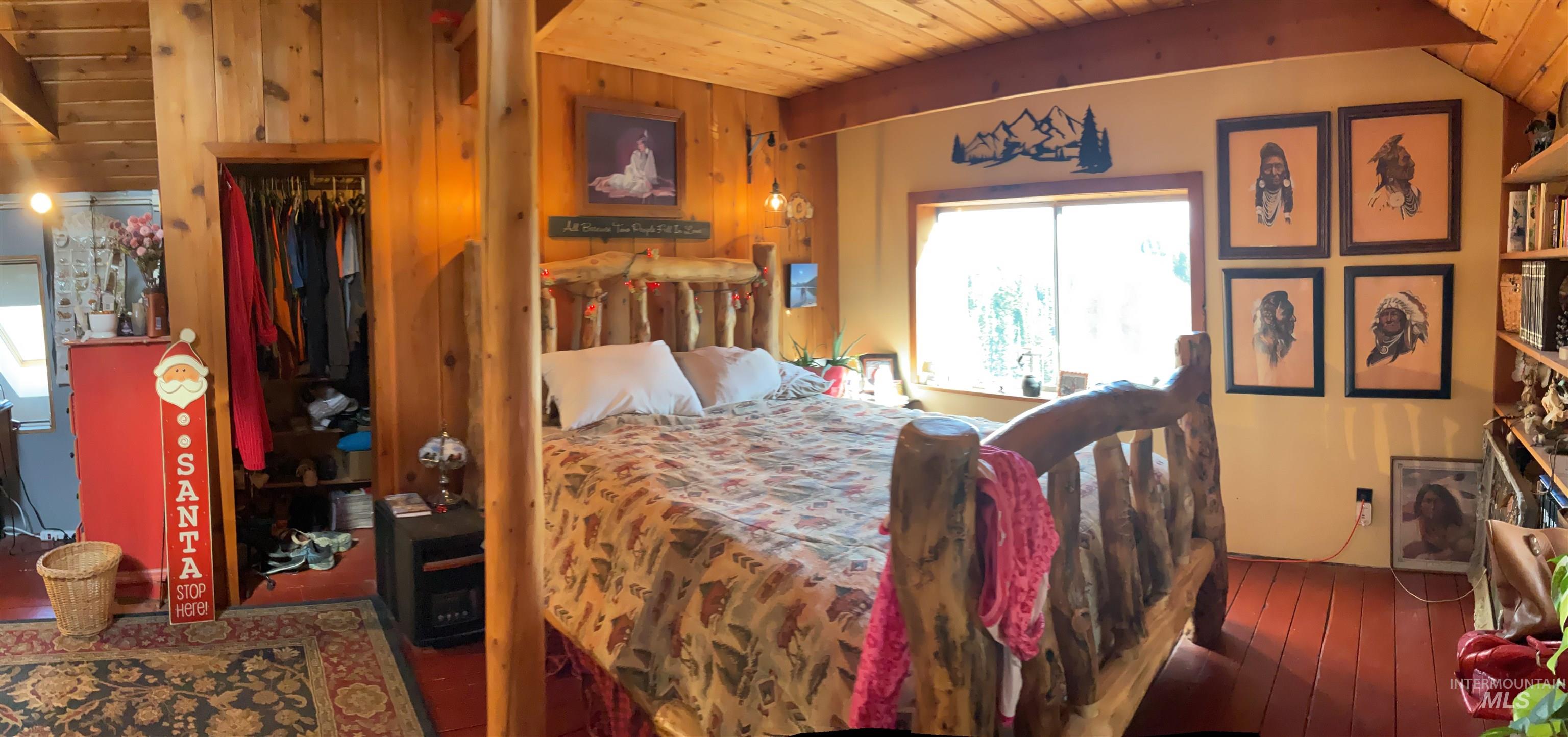 176 West Buffalo Gulch Road Elk City, ID 83525 - Photo 21 of 38 Wood-paneled room featuring a sloped ceiling with exposed beams, a built-in wall niche, and warm-toned wood-finish flooring