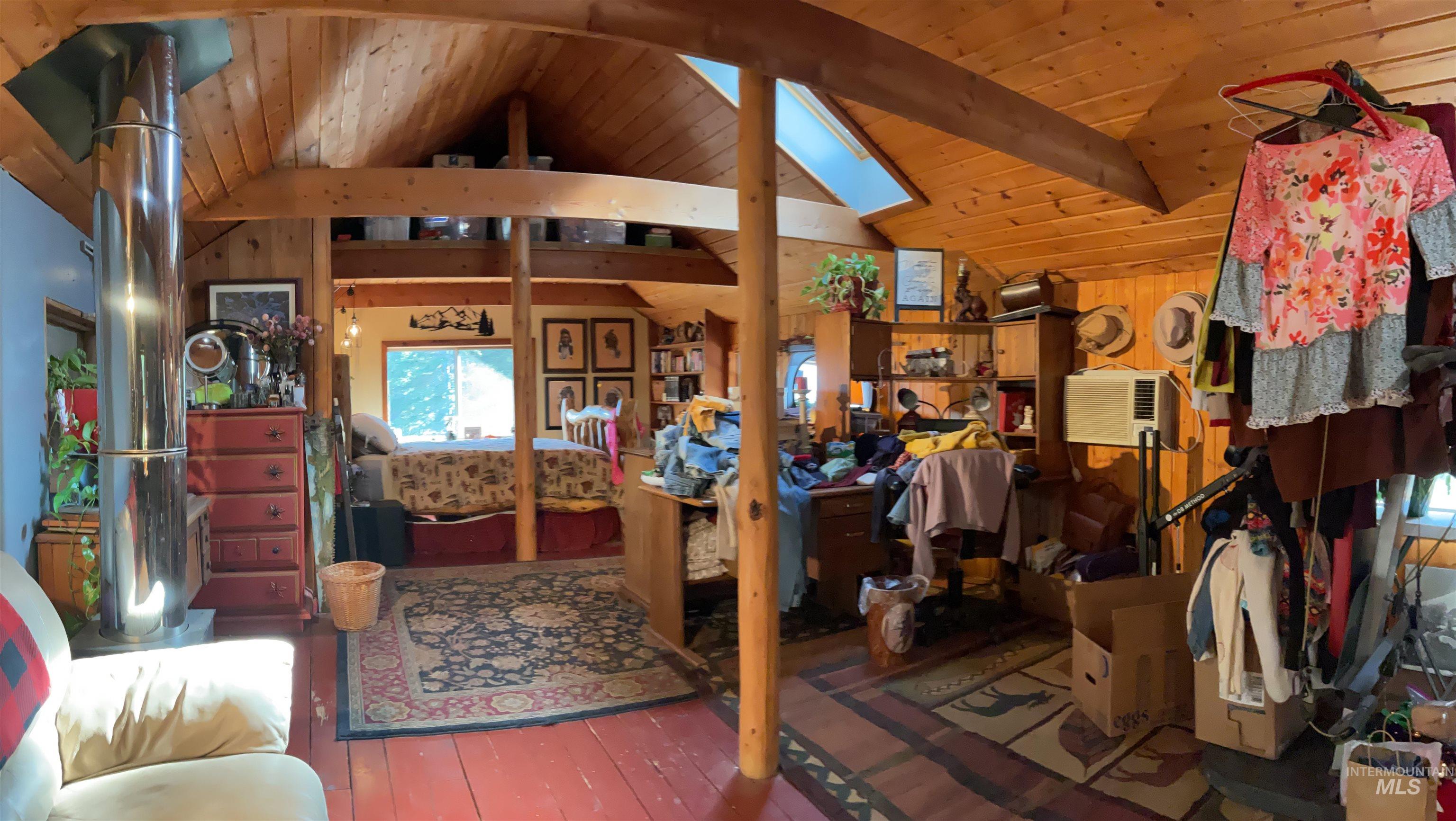 176 West Buffalo Gulch Road Elk City, ID 83525 - Photo 22 of 38 Wood-paneled room featuring exposed beams, sloped wood ceiling, and a skylight