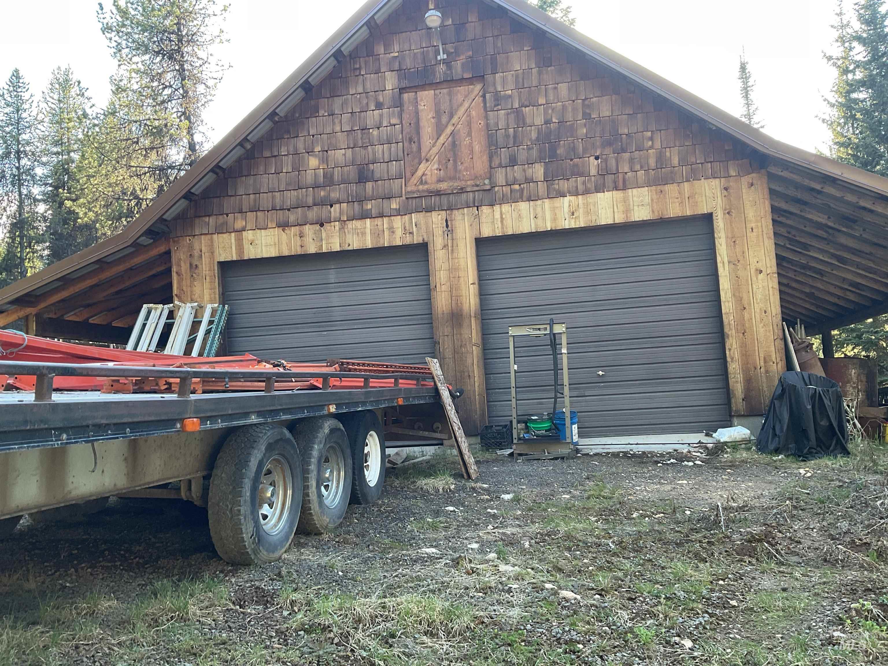 176 West Buffalo Gulch Road Elk City, ID 83525 - Photo 36 of 38 Two-bay garage building with wood shingle siding and natural wood paneling