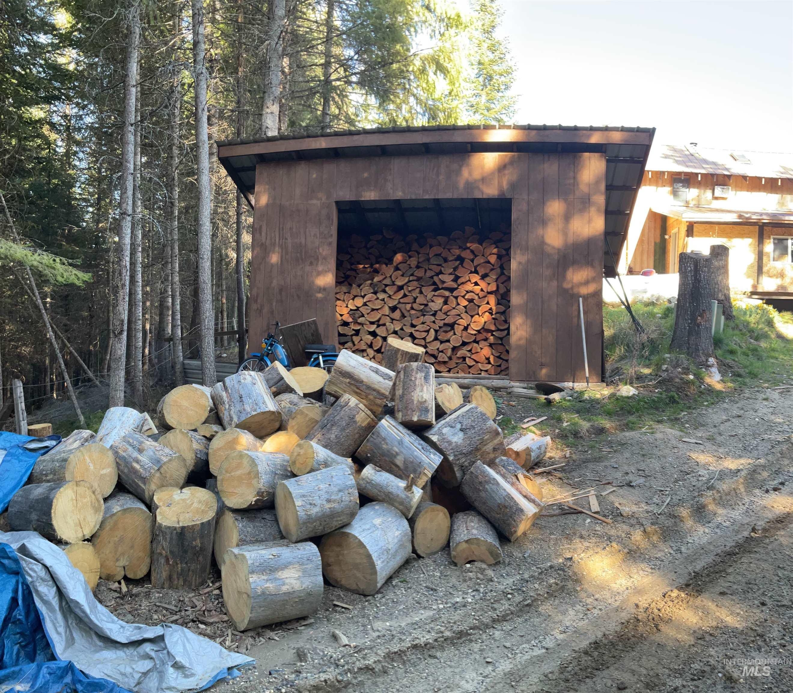 176 West Buffalo Gulch Road Elk City, ID 83525 - Photo 37 of 38 Wood storage shed featuring a metal roof and a full cord of stacked firewood