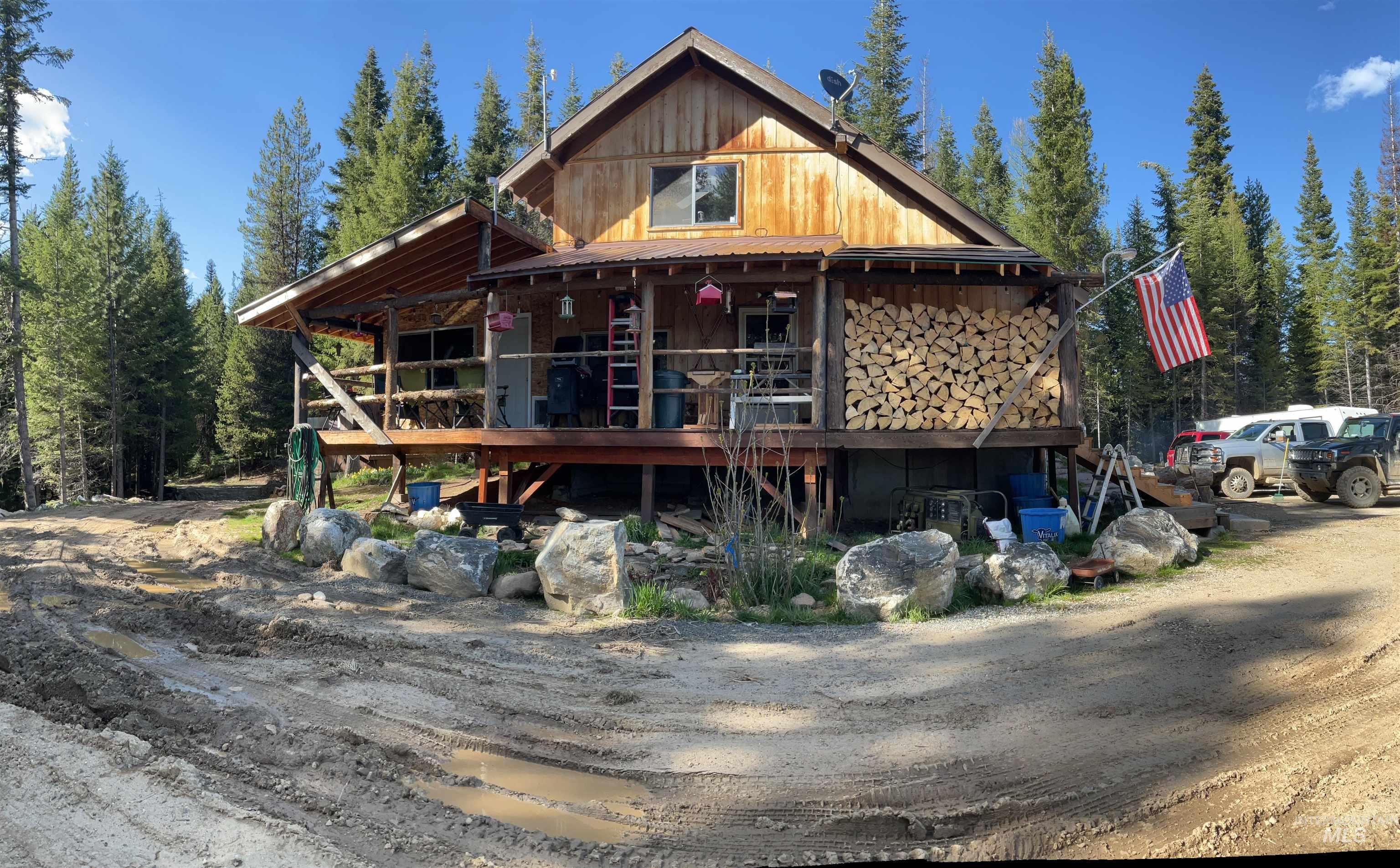 176 West Buffalo Gulch Road Elk City, ID 83525 - Photo 10 of 38 Rustic wood-sided structure with a covered porch and exposed foundation
