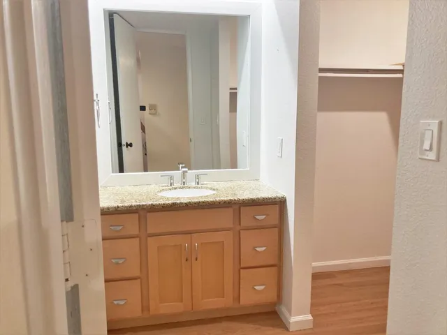 a bathroom with a granite countertop sink and a mirror