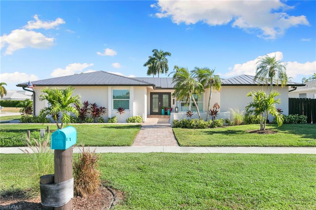 321 Columbus Way Marco Island, FL 34145 - Photo 1 of 40 Ranch-style house with french doors, a metal roof, stucco siding, and a front yard