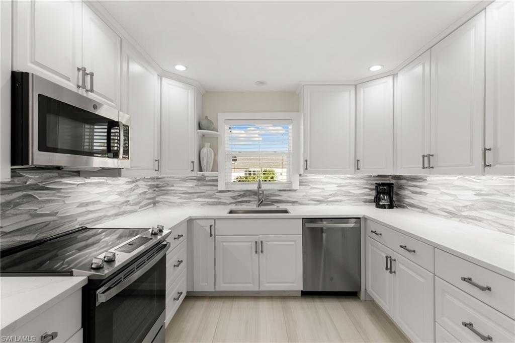 321 Columbus Way Marco Island, FL 34145 - Photo 11 of 40 Kitchen with appliances with stainless steel finishes, white cabinetry, open shelves, decorative backsplash, and recessed lighting