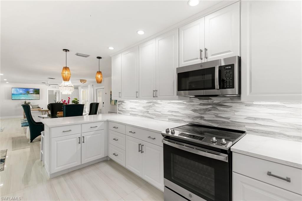 321 Columbus Way Marco Island, FL 34145 - Photo 40 of 40 Kitchen featuring stainless steel appliances, white cabinets, open floor plan, decorative light fixtures, and recessed lighting