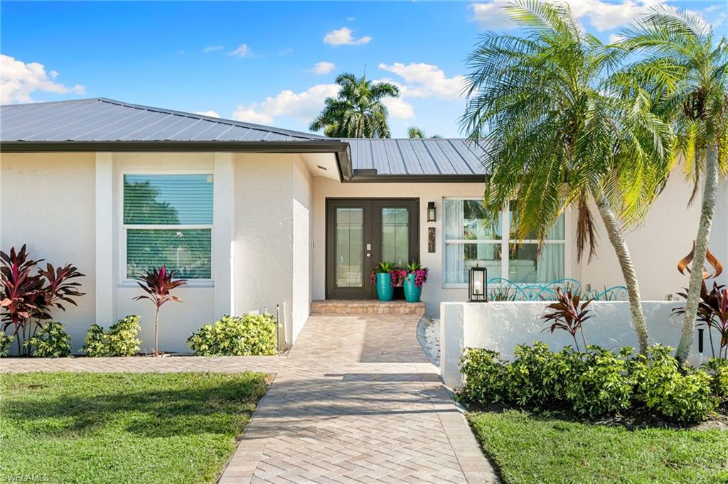 321 Columbus Way Marco Island, FL 34145 - Photo 2 of 40 Doorway to property with stucco siding, a metal roof, and french doors