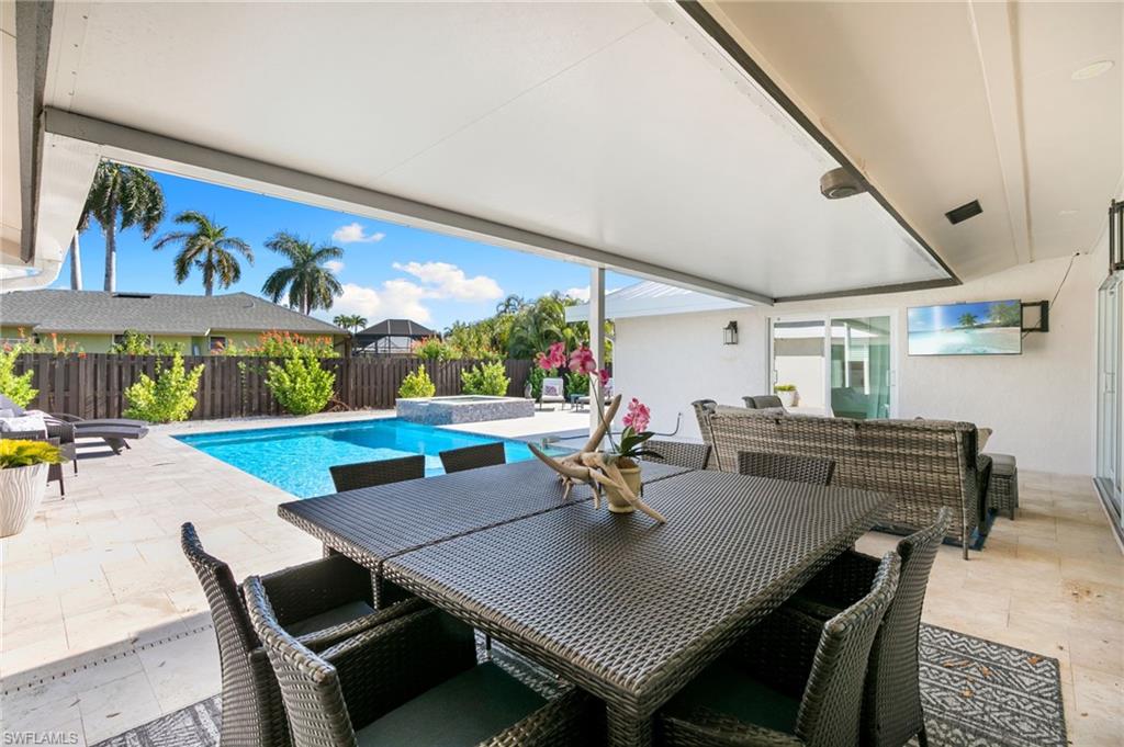 321 Columbus Way Marco Island, FL 34145 - Photo 29 of 40 View of swimming pool featuring a patio, outdoor dining area, a fenced backyard, and a pool with connected hot tub