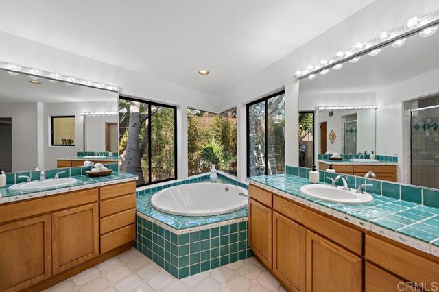 a bathroom with a granite countertop sink and a large mirror