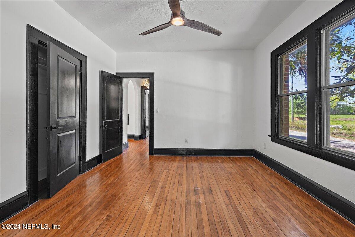 2015 Reed Avenue Jacksonville, FL 32207 - Photo 15 of 27 a view of a room with wooden floor a ceiling fan and windows