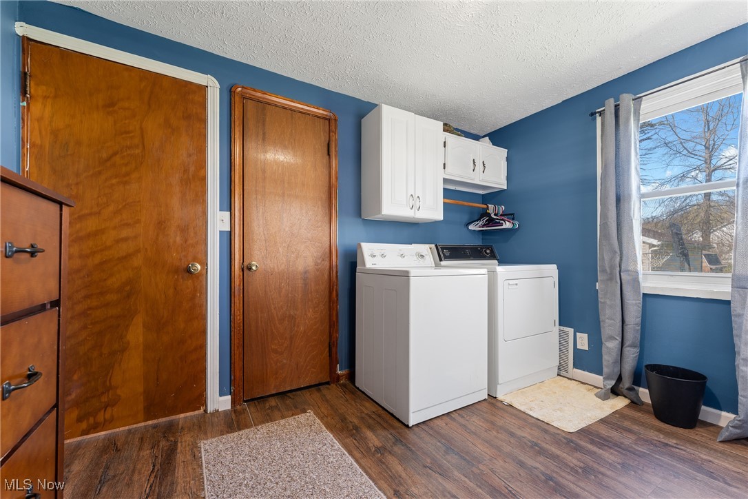 123 North Seneca Street Rittman, OH 44270 - Photo 14 of 32 Laundry room with cabinet space, a textured ceiling, dark wood-style floors, and independent washer and dryer