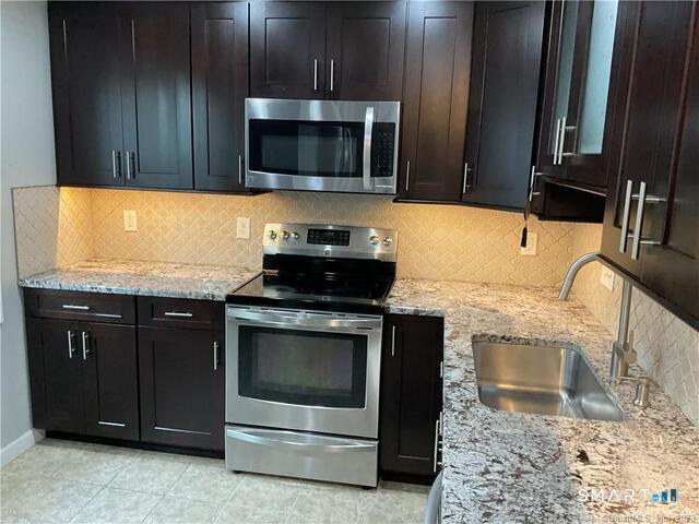25 Padanaram Road, Unit 84 Danbury, CT 06811 - Photo 1 of 34 a kitchen with granite countertop wooden cabinets and stainless steel appliances