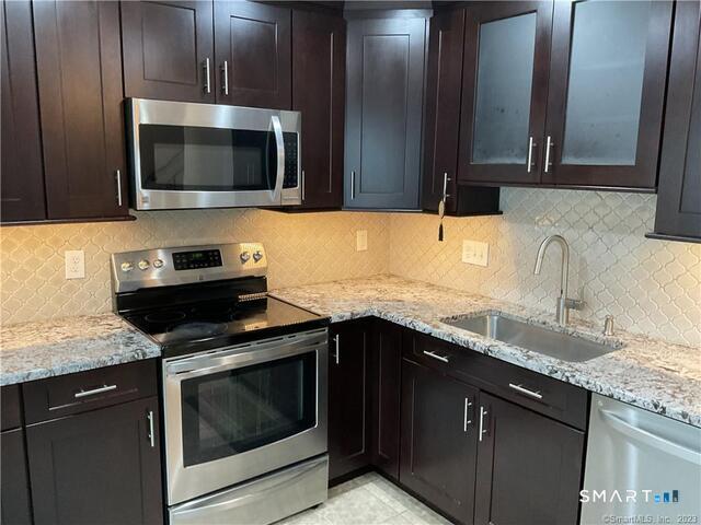 25 Padanaram Road, Unit 84 Danbury, CT 06811 - Photo 2 of 34 a kitchen with granite countertop a sink stove and microwave