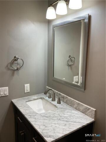 25 Padanaram Road, Unit 84 Danbury, CT 06811 - Photo 21 of 34 a bathroom with a granite countertop sink and a mirror