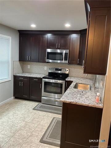 25 Padanaram Road, Unit 84 Danbury, CT 06811 - Photo 3 of 34 a kitchen with kitchen island granite countertop cabinets and steel stainless steel appliances