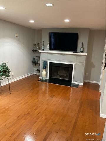 25 Padanaram Road, Unit 84 Danbury, CT 06811 - Photo 9 of 34 a living room with a fireplace and a flat screen tv