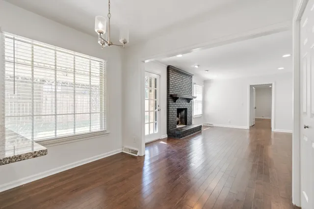 a view of empty room with wooden floor and fireplace