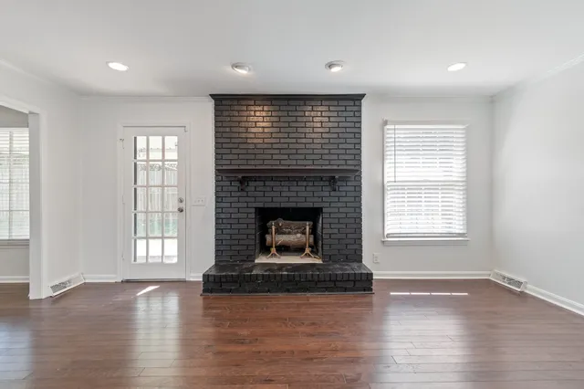 a living room with a fireplace and wooden floor