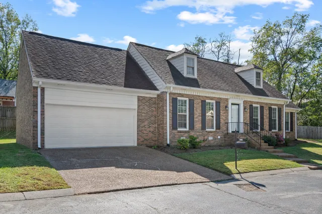 a view of a white house with a yard and large windows