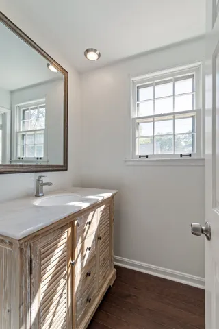 a bathroom with a granite countertop sink and a window