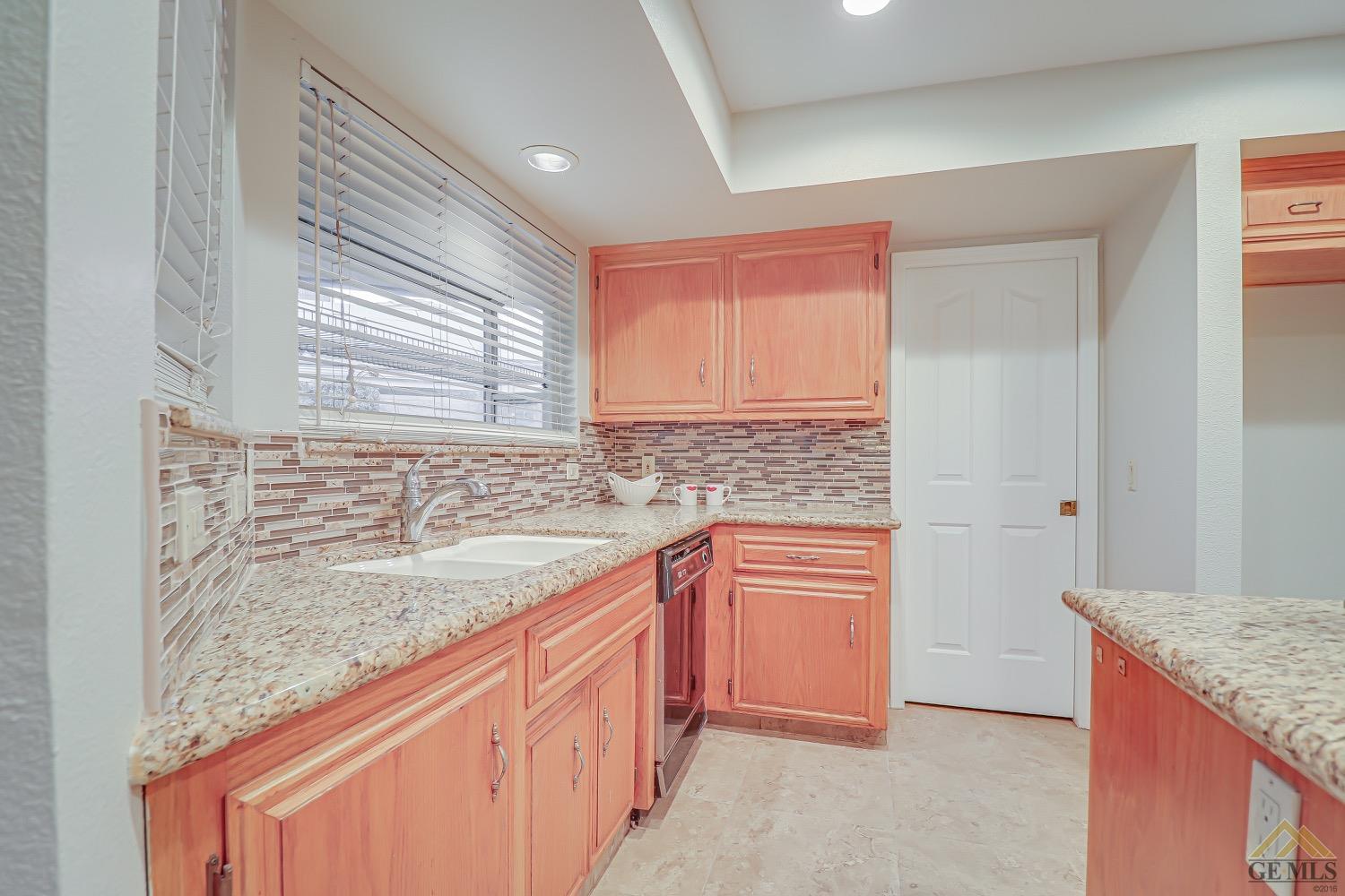 Undisclosed Address Bakersfield, CA 93314 - Photo 14 of 38 a kitchen with granite countertop sink stove and cabinets