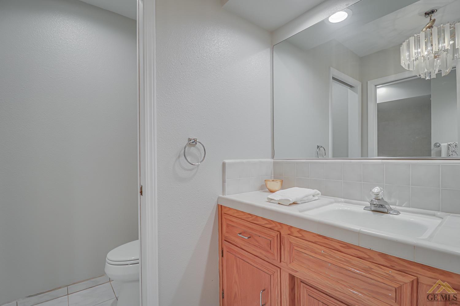 Undisclosed Address Bakersfield, CA 93314 - Photo 23 of 38 a bathroom with a sink a toilet and a mirror