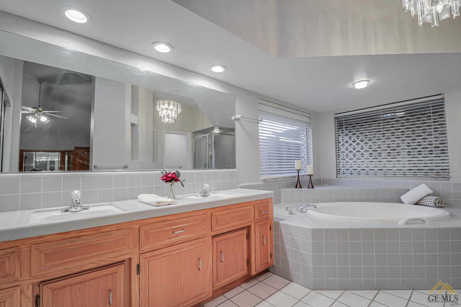 Undisclosed Address Bakersfield, CA 93314 - Photo 28 of 38 a bathroom with a tub sink and mirror