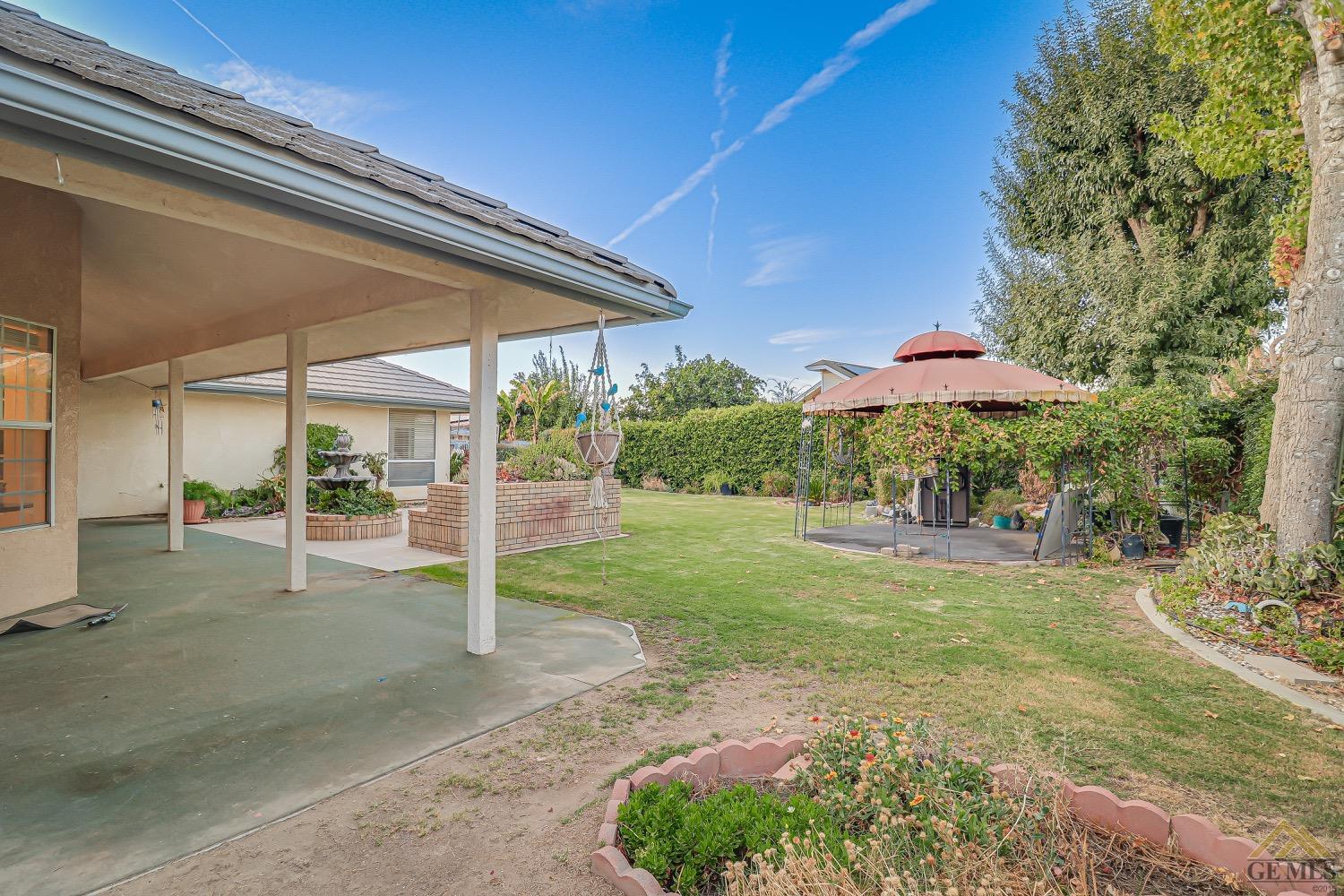 Undisclosed Address Bakersfield, CA 93314 - Photo 34 of 38 a view of a patio with a table and chairs under an umbrella