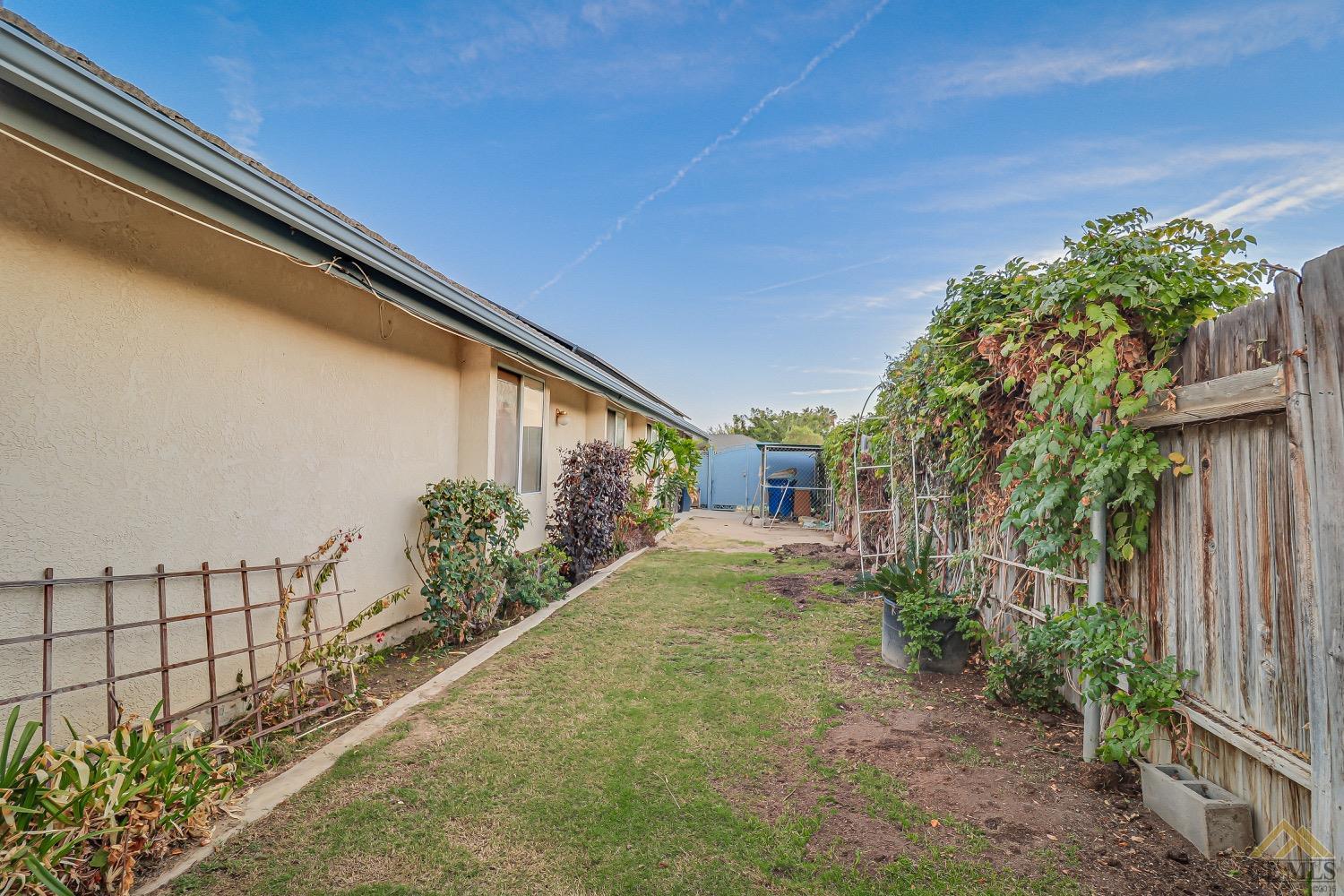 Undisclosed Address Bakersfield, CA 93314 - Photo 38 of 38 a yellow house with flower garden in front of it