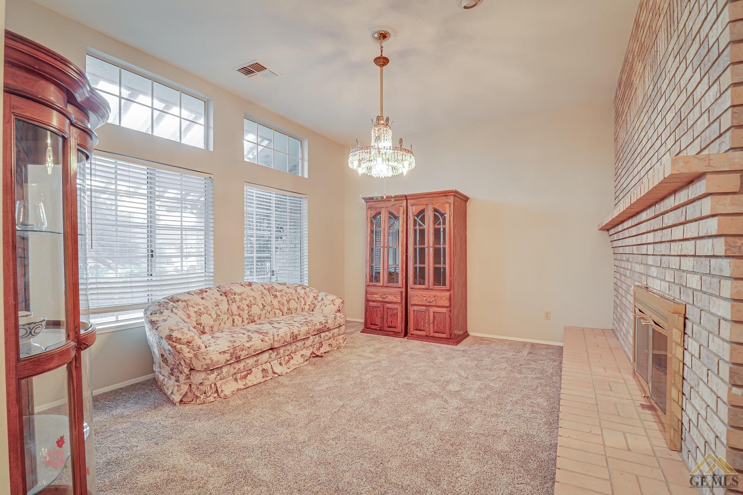 Undisclosed Address Bakersfield, CA 93314 - Photo 6 of 38 a living room with furniture a fireplace and a chandelier